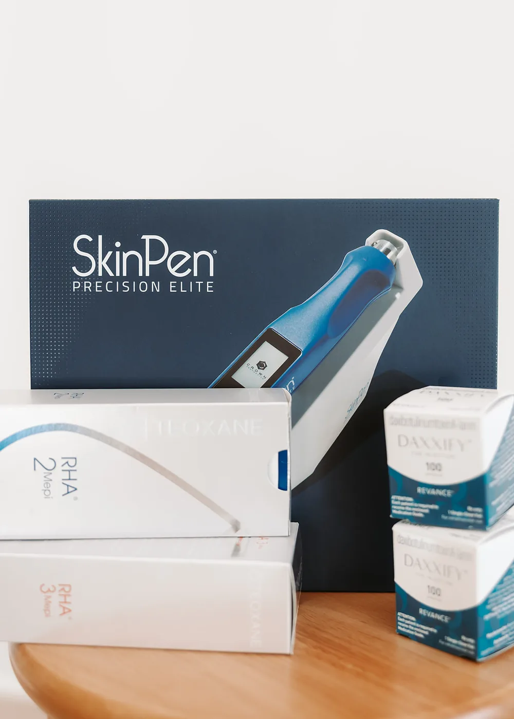 SkinPen, RHA filler and Daxxify boxes on a table in the studio
